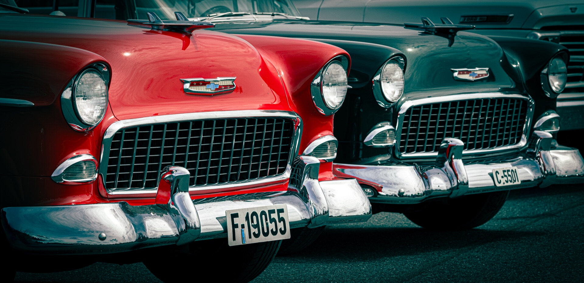 Rød og grønn Chevrolet Bel Air fra 1950-tallet parkert side om side på bilutstilling
