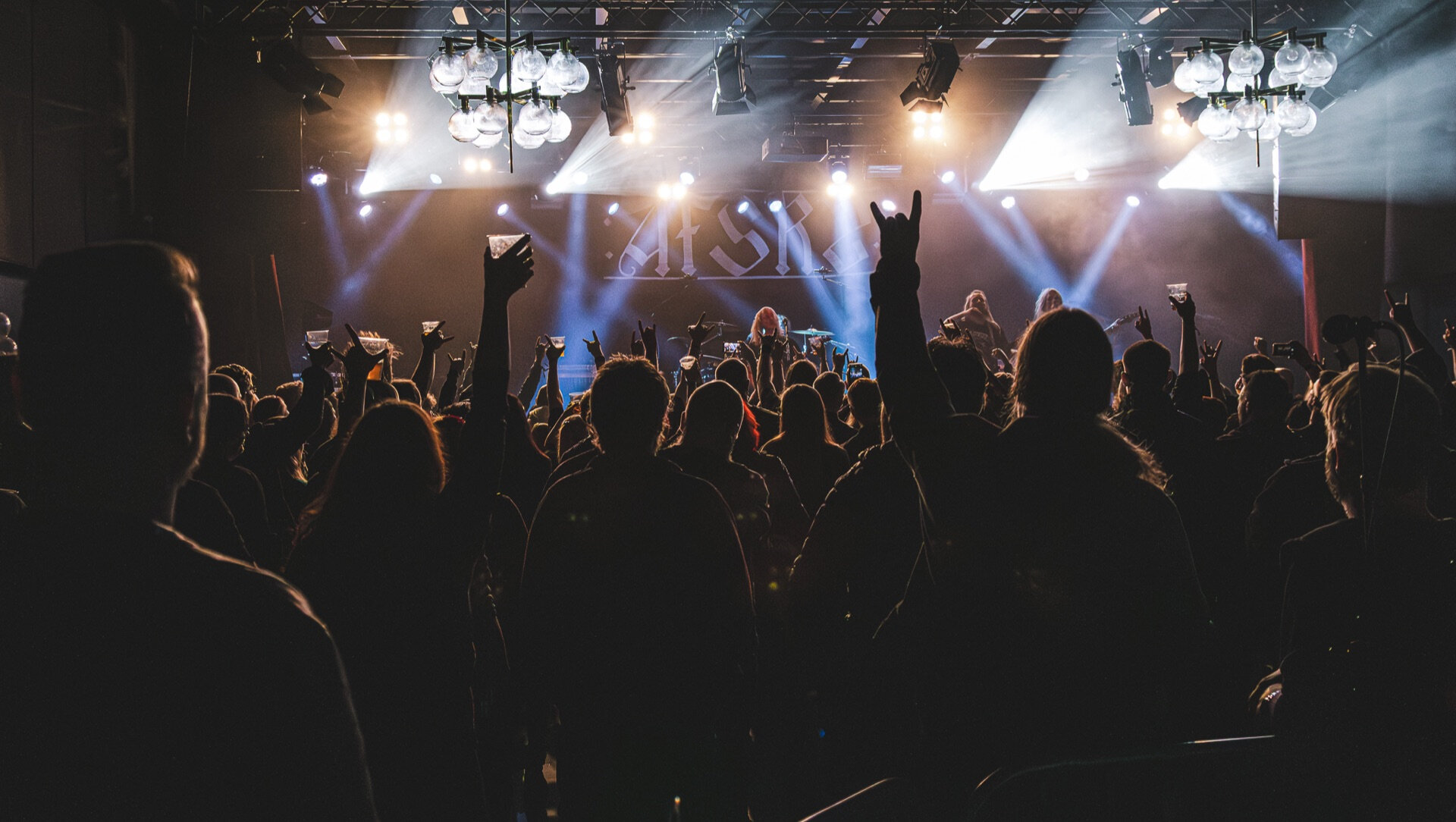Konsertpublikum i silhuett mot krysslys fra scenen