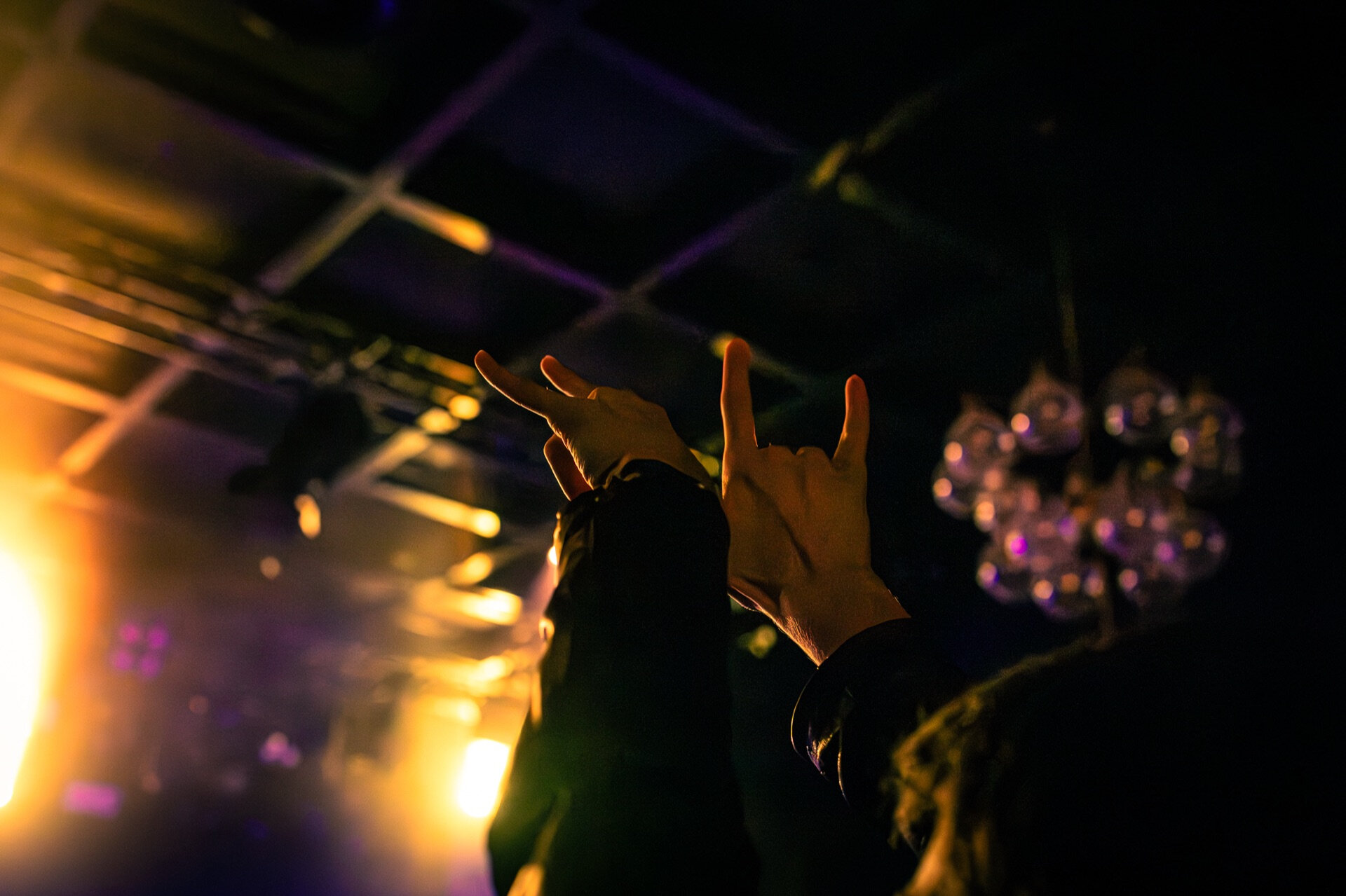 Stort publikum løfter never samlet foran lyslenker på konsertsted