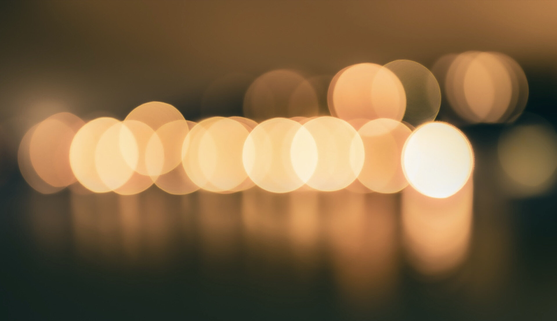 Abstrakt bokeh av gyllent lys reflektert i vann